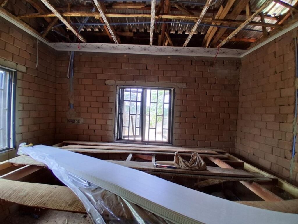 Installing ceiling and utilities in staff quarters at Kwali Farm